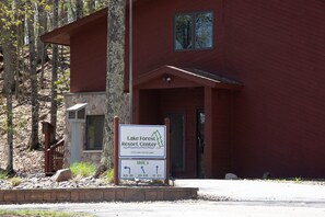 Ein Gebäude mit einem Schild für Lake Forest Resort Center, einer Steinfassade und einer Holztreppe.