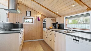 A compact kitchen with wooden cabinets, a stainless steel range, a built-in oven, and a dishwasher.