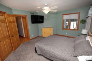A bedroom with a bed, a ceiling fan, a TV, a dresser, and a window. - Lakefront | 2 Saunas, Firepit, Kayaks, Dock & Boat (Lake)