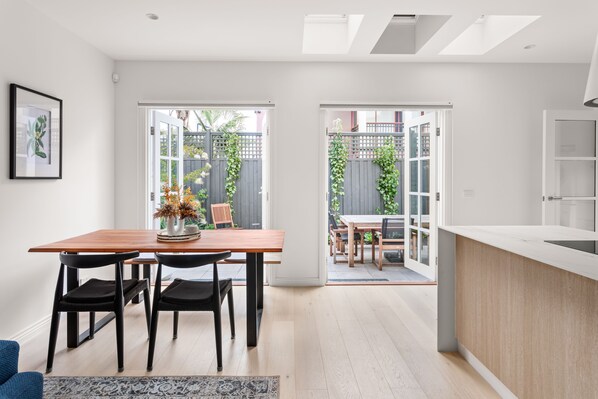 Una cocina moderna con encimera de madera y zona de comedor con mesa y sillas.