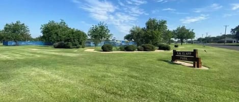 A well-maintained grassy area with a sign reading "K.J. Glapp Park".