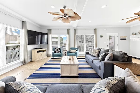 Bright, stylish living room with cozy seating, smart TV, and a cozy vibe