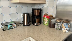 A kitchen with a coffee maker, a box of bamboo paper towels, and jars with lids. - Independent apartment in Jorwert near Leeuwarden, Sneek, Bolsward and Franeker (Jorwert)