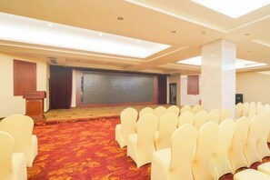 A conference room with rows of chairs, a podium, and a stage. - Senlin Hotel (Guiyang)