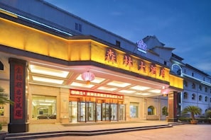 A hotel with a prominent sign, a well-lit entrance, and a traditional architectural style. - Senlin Hotel (Guiyang)