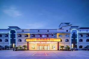 A hotel with a large entrance, multiple floors, and a parking lot. - Senlin Hotel (Guiyang)