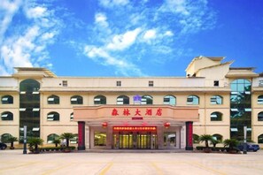 A hotel with a large entrance, multiple windows, and a clear sky.