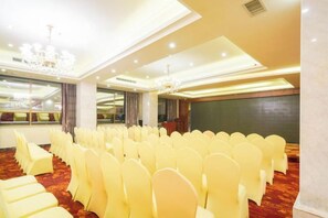 A conference room with rows of chairs, a podium, and a large screen. - Senlin Hotel (Guiyang)
