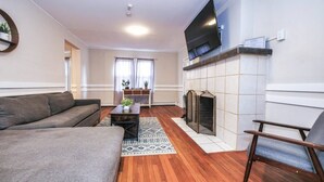 A living room with a fireplace, a sofa, a TV, and a coffee table.