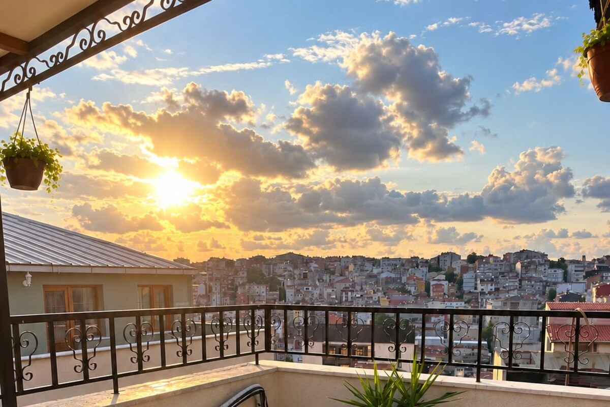 A balcony with a table and chairs, overlooking a cityscape during sunset.