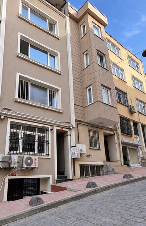 A multi-story residential building with a flat facade, large windows, and air conditioning units attached to the exterior. - Taksim cozy apartments (Istanbul)