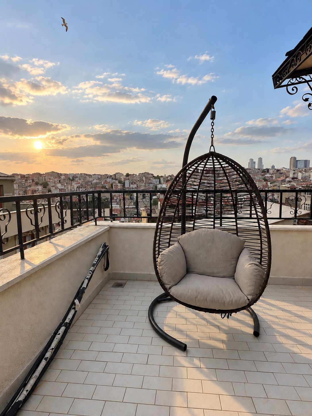 Een hangstoel op een balkon met uitzicht op de stad.