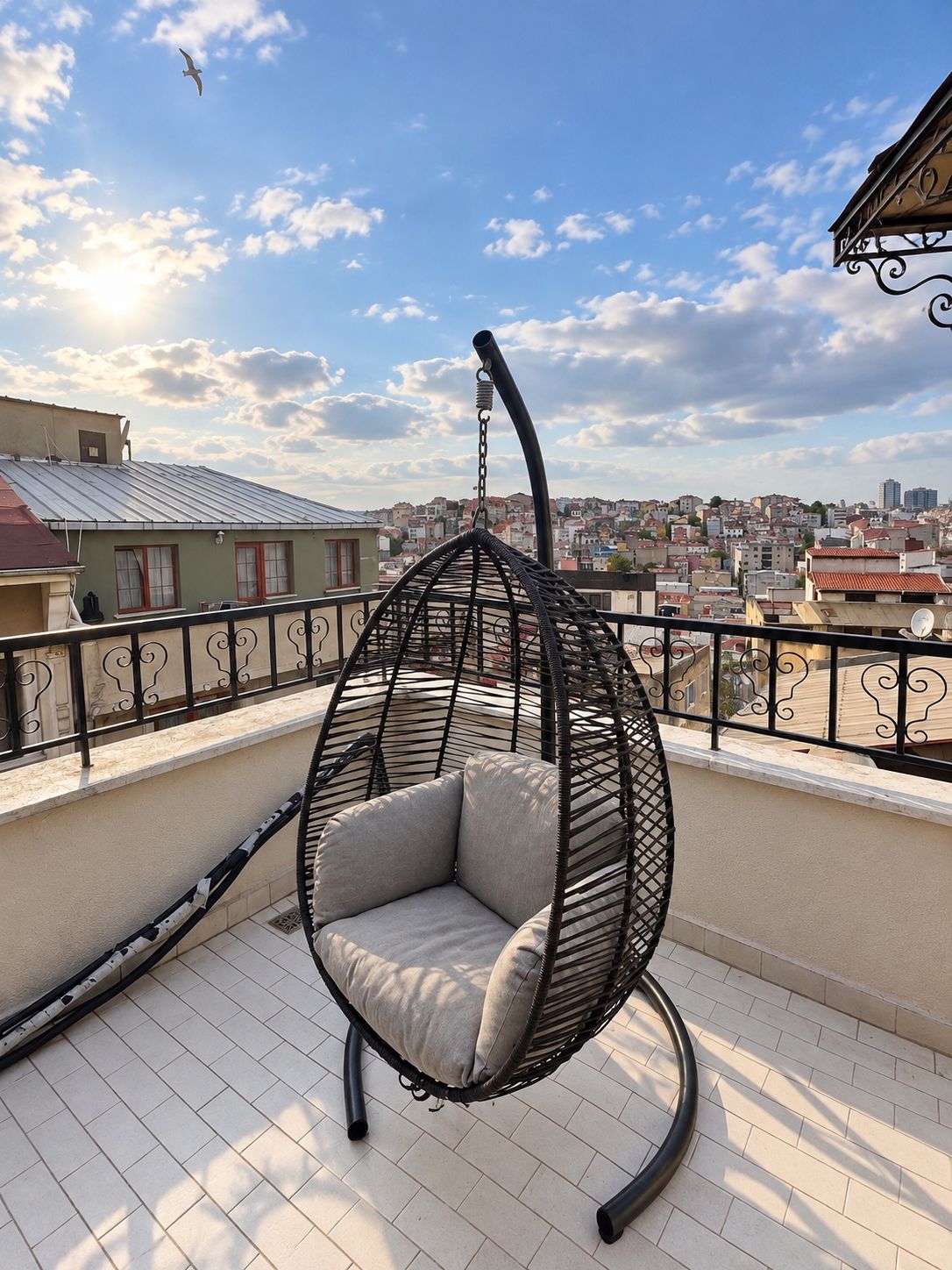 Una silla colgante en un balcón con vistas a la ciudad.