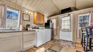 Una cocina compacta equipada con lavadora, refrigerador y microondas.