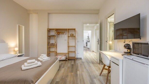 A bedroom with a bed, a desk, a television, and a wardrobe. - Ostiense Flat&Rooms - Double Room by Rentbeat (Roma)