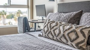 Una habitación de hotel con una cama, un escritorio y una computadora.