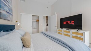 A bedroom with a bed, a TV displaying 'NETFLIX', and a wardrobe. - Lux Penthouse~King Beds~Workspaces~Parking~ Near Zoo, Balboa Park! (San Diego)