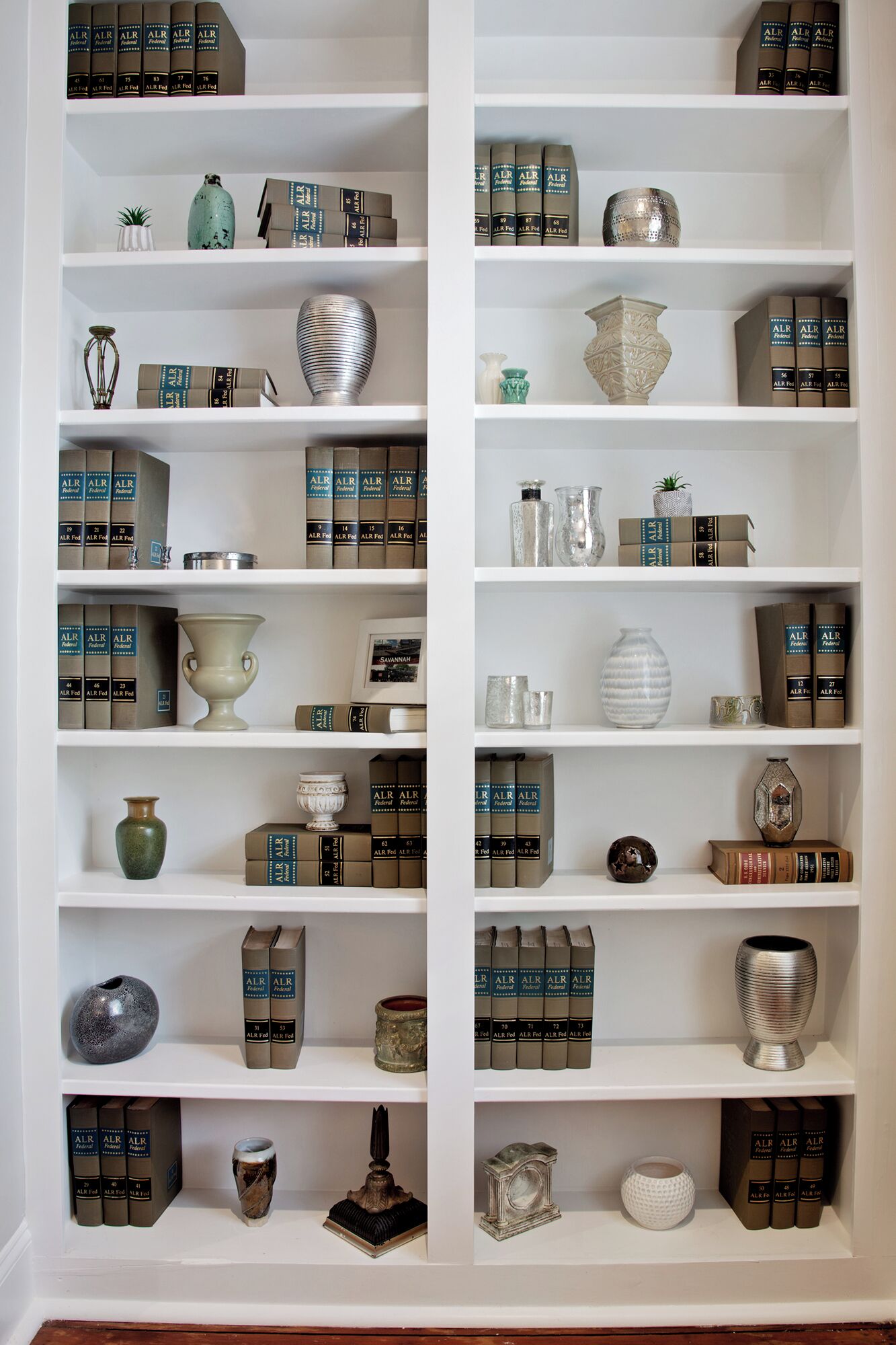 A bookshelf with multiple shelves, each containing books and decorative items.