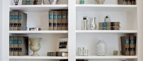 A bookshelf with multiple shelves, each containing books and decorative items.