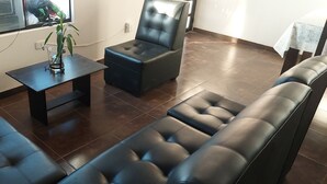 A living room with a sofa, a coffee table, and a chair. - Lonko Hostel Arequipa (Arequipa)