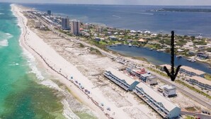 An aerial view of a coastal area with a beach, buildings, and a marina. - 4 Beds/4Baths ROOFTOP! Gorgeous MODERN 360 degree views STEPS TO THE BEACH! (Pensacola Beach)