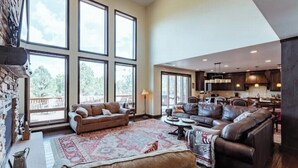 A spacious living area with large windows, a fireplace, and a cozy seating arrangement. - Zion Views- The Retreat +Resort Access (Orderville)