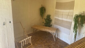 Una stanza accogliente e piccola con un'amaca, una panca e una tenda decorata.