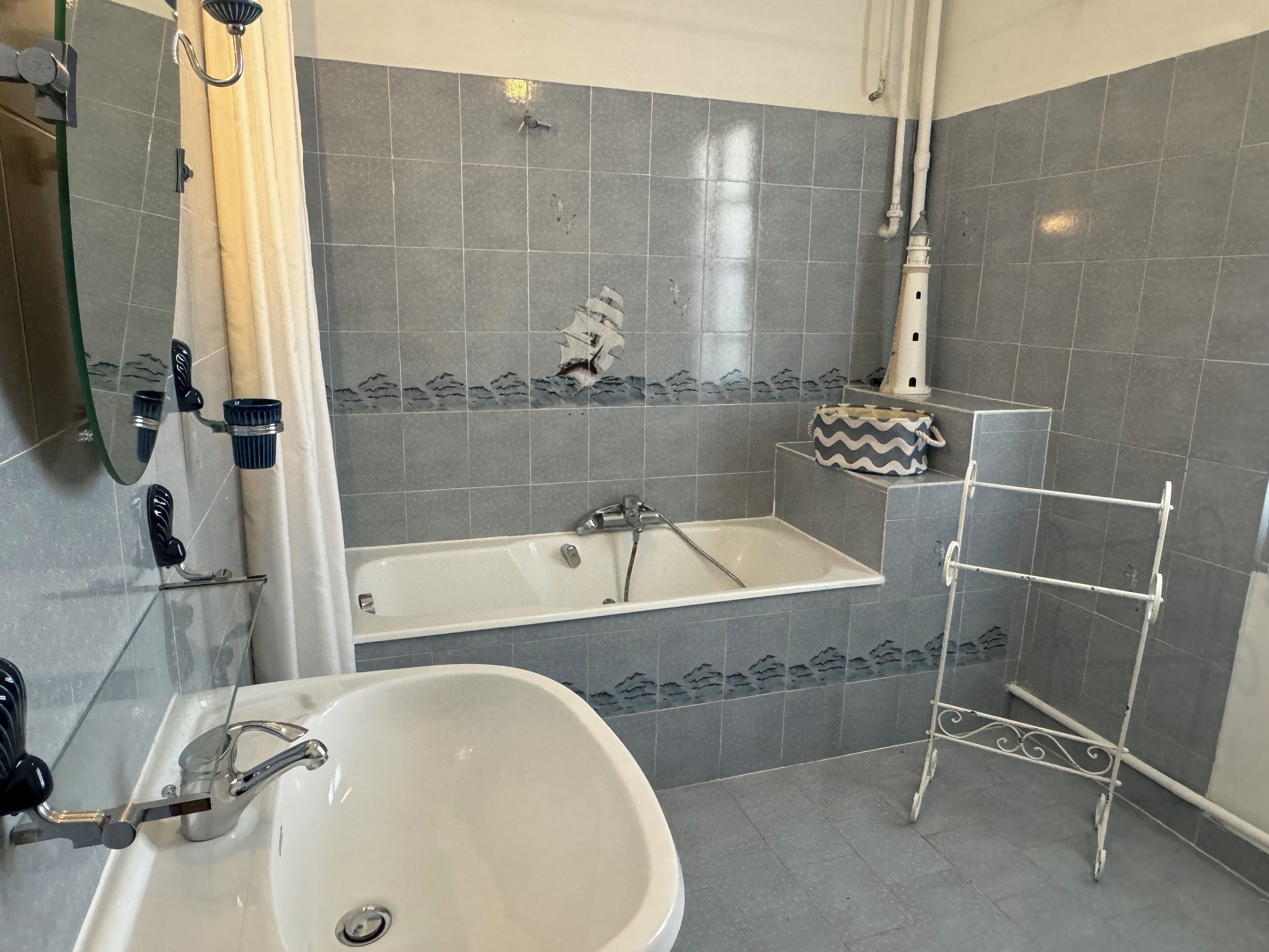 A bathroom with a bathtub, a sink, and a towel rack.
