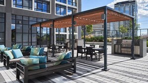 An outdoor patio area with seating and a grill. - High End 6 people Apartment Islington Etobicoke (Toronto)