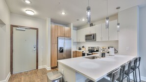 A modern kitchen with a central island, stainless steel appliances, and pendant lighting.