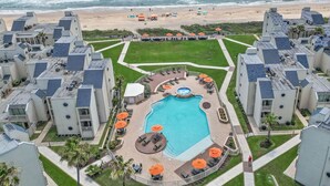 Un complexe hôtelier doté d’une piscine centrale, de plusieurs espaces de détente et offrant une vue sur la plage.