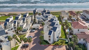 Un quartier résidentiel en bord de mer, avec des immeubles modernes, une plage et une vue dégagée sur l’océan.