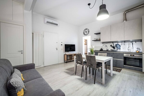 A modern apartment with a dining area, kitchen, and living room.