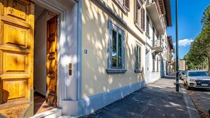 Un bâtiment doté d’une grande porte en bois, d’une enseigne portant le numéro « 12 » et d’une rangée de fenêtres.