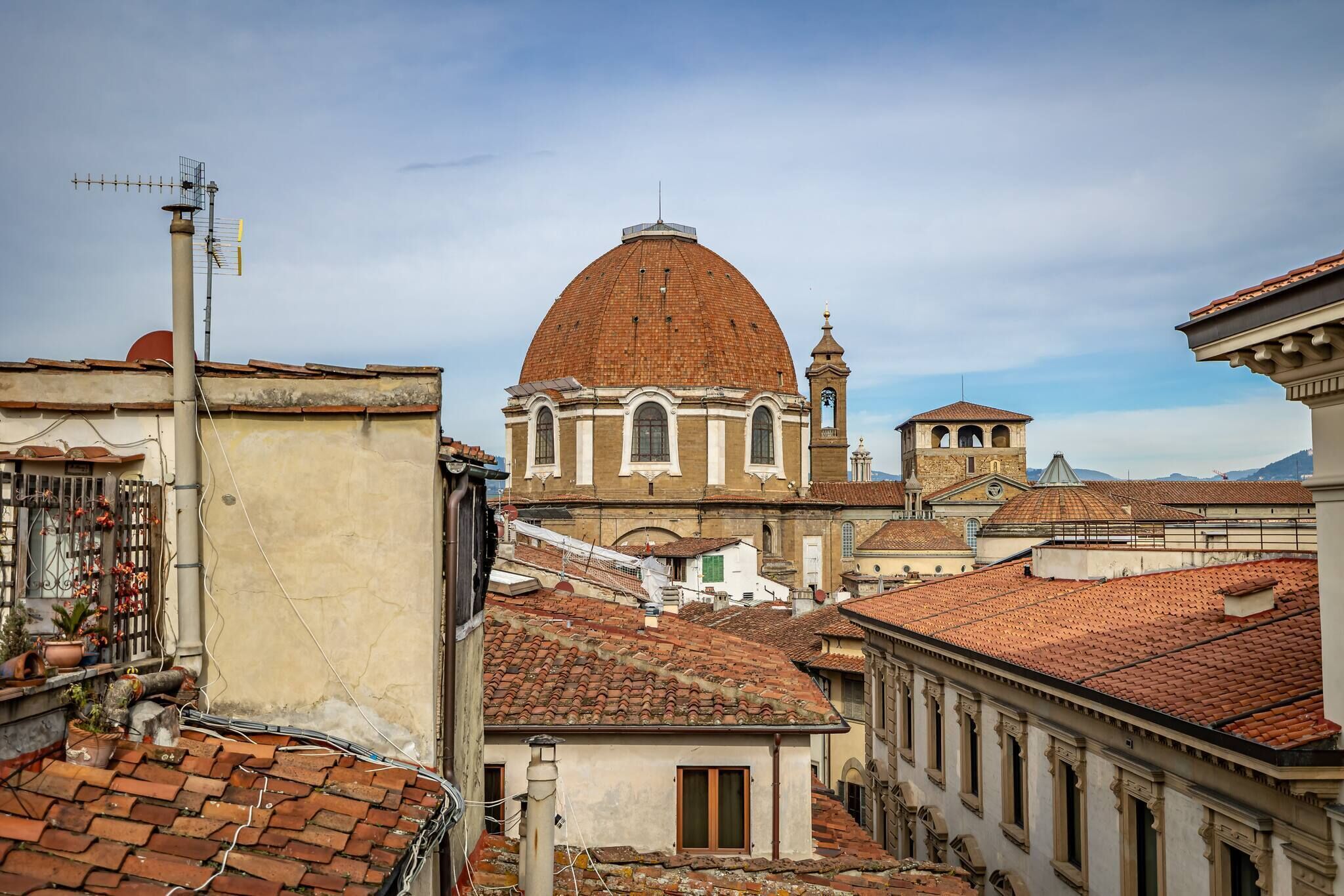 Un edificio storico con una cupola imponente e un campanile, circondato da architetture tradizionali.