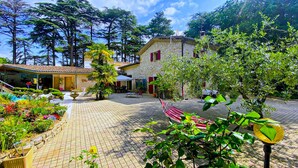 A courtyard with a stone building, outdoor seating, and lush greenery. - Amazing home in Saulce sur Rhône (Saulce sur Rhône)