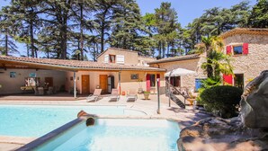 A pool area with lounge chairs, a stone building, and a staircase leading to a second floor. - Amazing home in Saulce sur Rhône (Saulce sur Rhône)