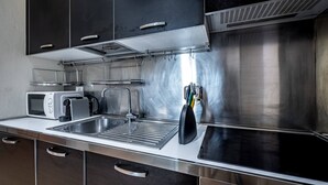 Une cuisine moderne équipée d’appareils électroménagers en acier inoxydable, d’un four à micro-ondes, d’un grille-pain et d’un évier.