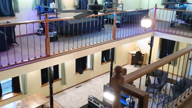 A multi-level living area with a staircase, seating arrangements, and a dining table. - Bank on it! Suite Bank (Sidney)