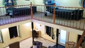 A spacious multi-level living area with a balcony, furnished with sofas, armchairs, and a coffee table. - Bank on it! Suite Bank (Sidney)