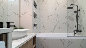 A modern bathroom with a white marble sink, a freestanding bathtub, and a shower with a black faucet. - Trendy & Private City Studios Near Cismigiu & Calea Victoriei (Bucharest)