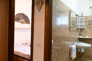 Un bagno con lavandino, specchio e portasciugamani.