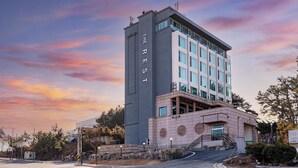 A multi-story building with a prominent vertical sign reading 'THE REST CAFE' and a lower sign indicating a cafe. - Incheon The Rest Hotel (Incheon)