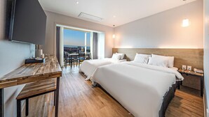 A hotel room with two beds, a desk, a TV, and a view of the city. - Incheon The Rest Hotel (Incheon)