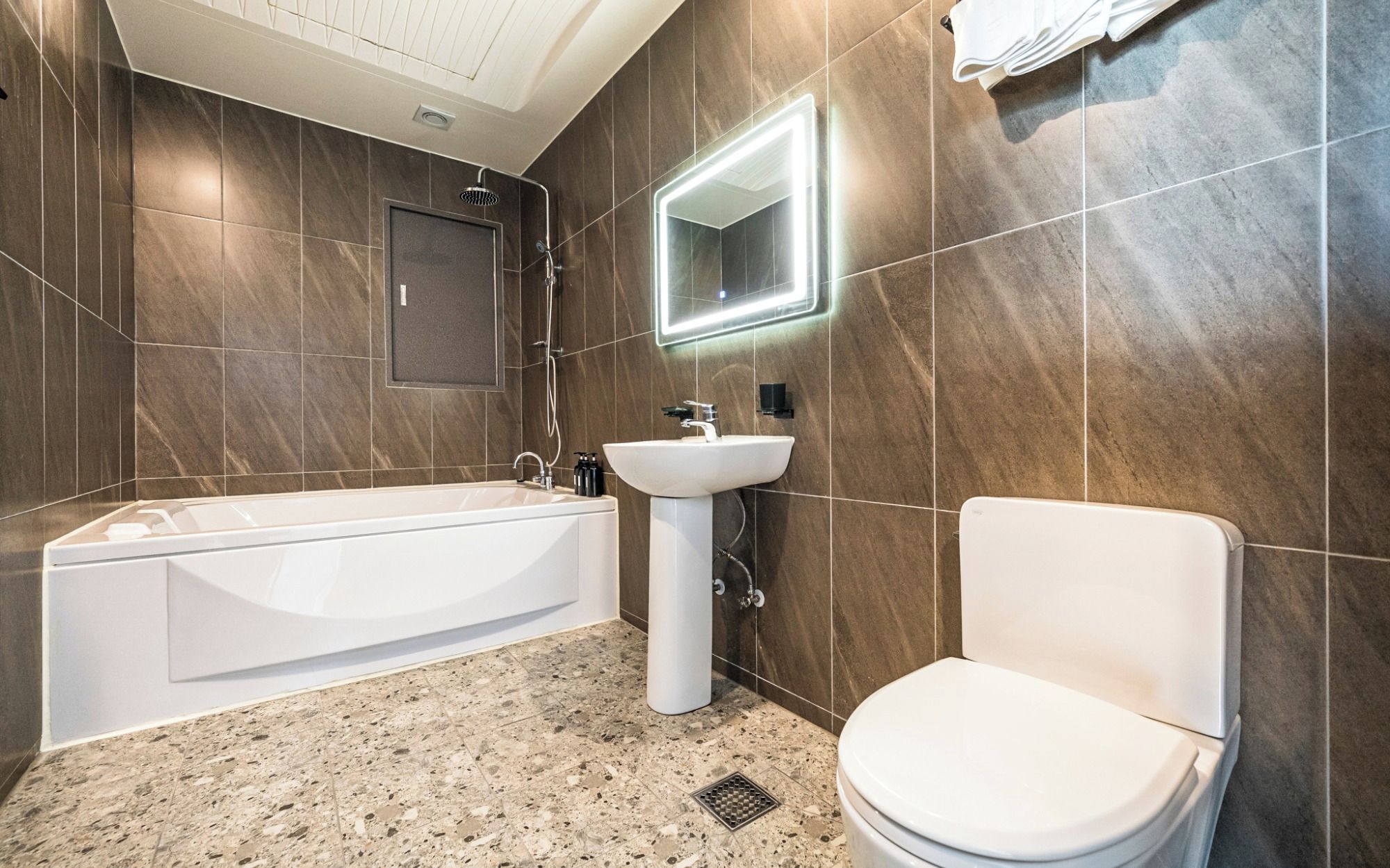 A modern bathroom with a bathtub, sink, and toilet.