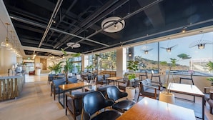 A modern restaurant with a high ceiling, exposed beams, and large windows offering views of the outdoors. - Incheon The Rest Hotel (Incheon)