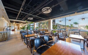 A modern restaurant with a high ceiling, exposed beams, and large windows offering views of the outdoors. - Incheon The Rest Hotel (Incheon)