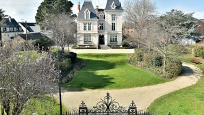 A large, historic building with a symmetrical facade, a central entrance, and a well-maintained lawn. - La Plage du Petit Port (Cancale)