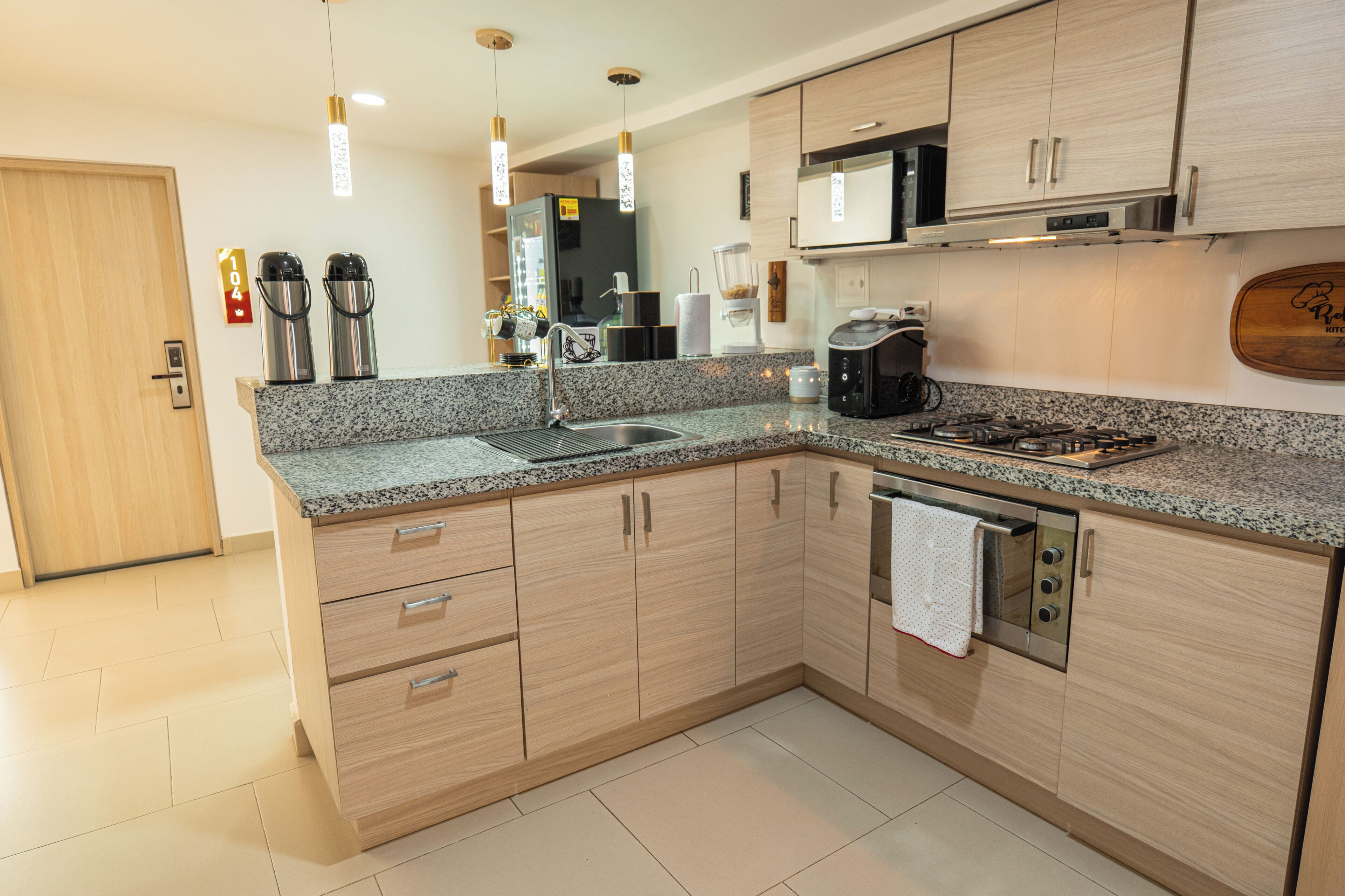 A modern kitchen with granite countertops, stainless steel appliances, and wooden cabinetry.
