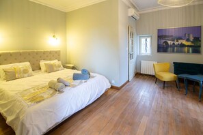 A hotel room with a large bed, a chair, a table, and a painting on the wall. - Between Mont Ventoux and Luberon, air-conditioned Provencal farmhouse with swimming pool, indoor... (MAZAN)